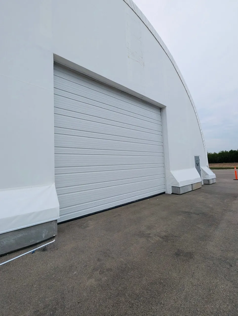 Completed fabric building with overhead door