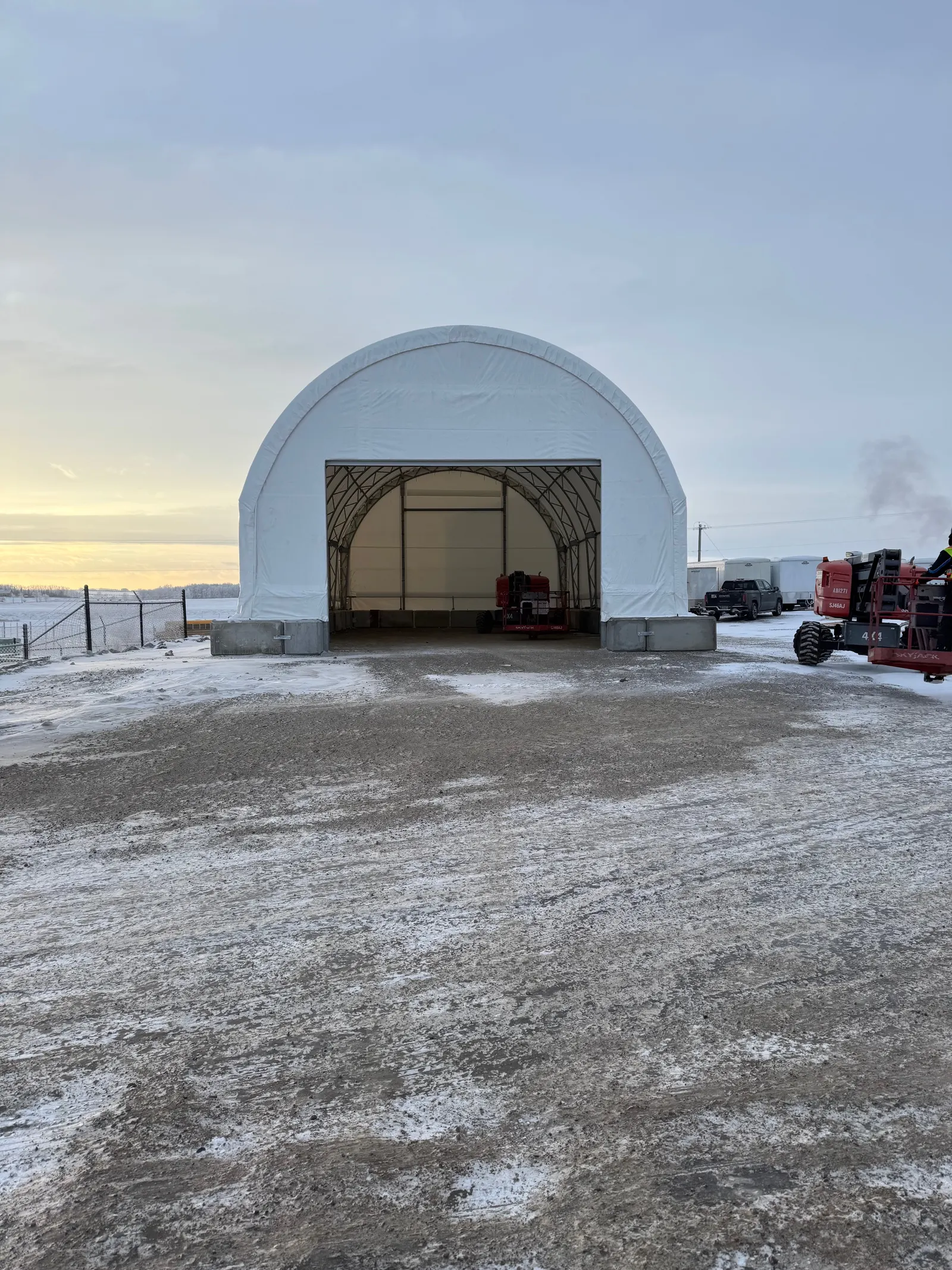 Fabric dome building installation on a prairie yard in winter