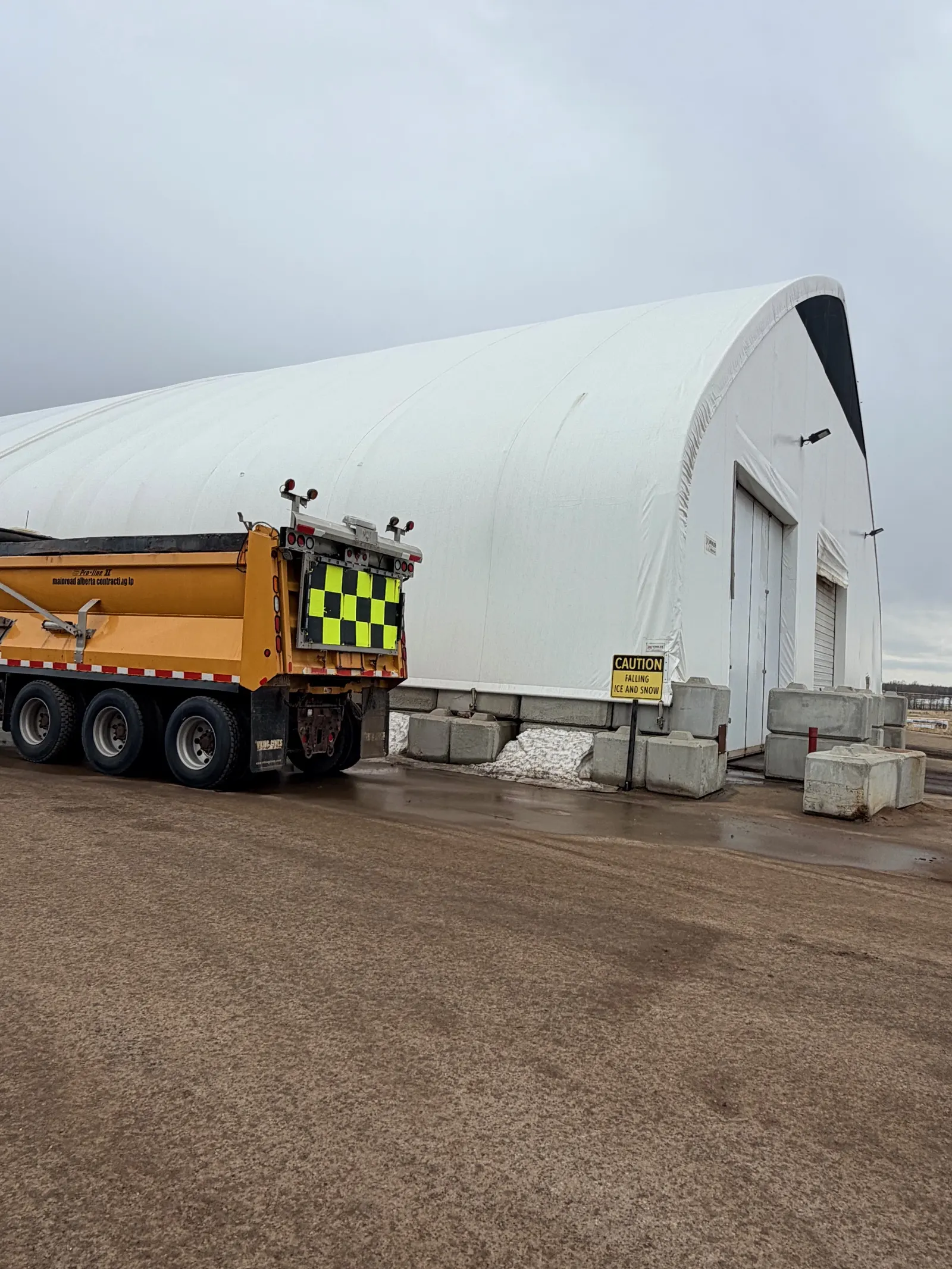 Sand storage building with highway maintenance truck